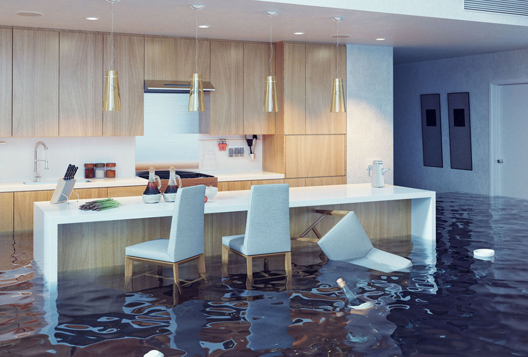 A modern, light-wood kitchen is heavily flooded with dark water, partially submerging several grey dining chairs and a large white island
